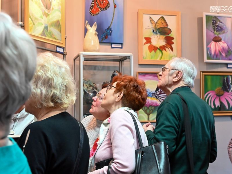 Na zdjęciu odwiedzający wystawę w MCK Browarna oglądają obrazy wiszące na ścianie