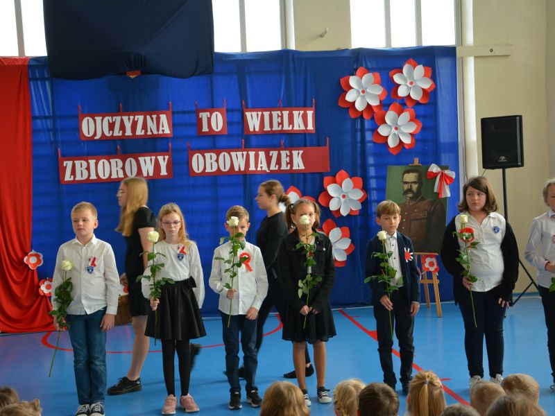 Na zdjęciu uczniowie SP nr 3 podczas uroczystej imprezy z okazji 11 Listopada. Uczniowie z biało-czerwonymi kokardami, trzymają w rekach białe różee